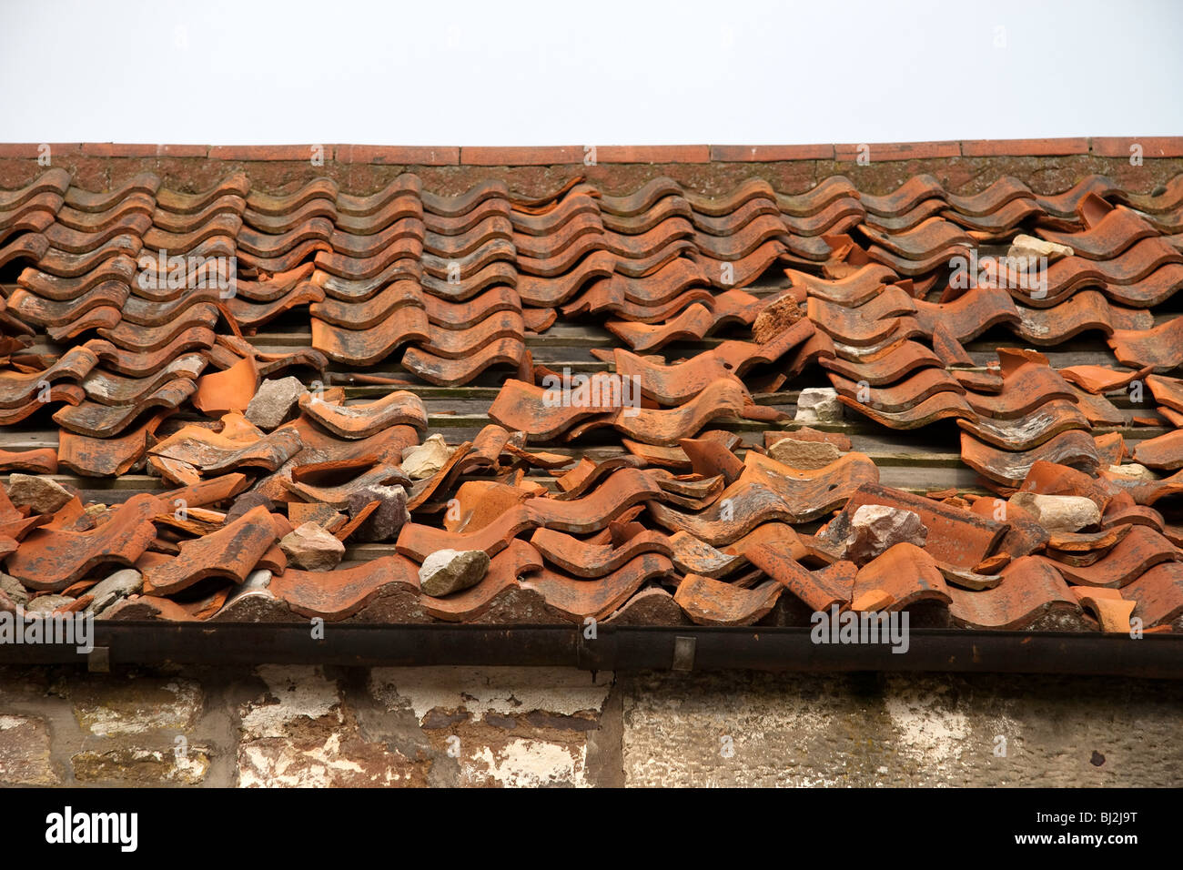Defekte und beschädigte Terrakotta-Fliesen auf dem Dach eines verlassenen Gebäudes Stockfoto