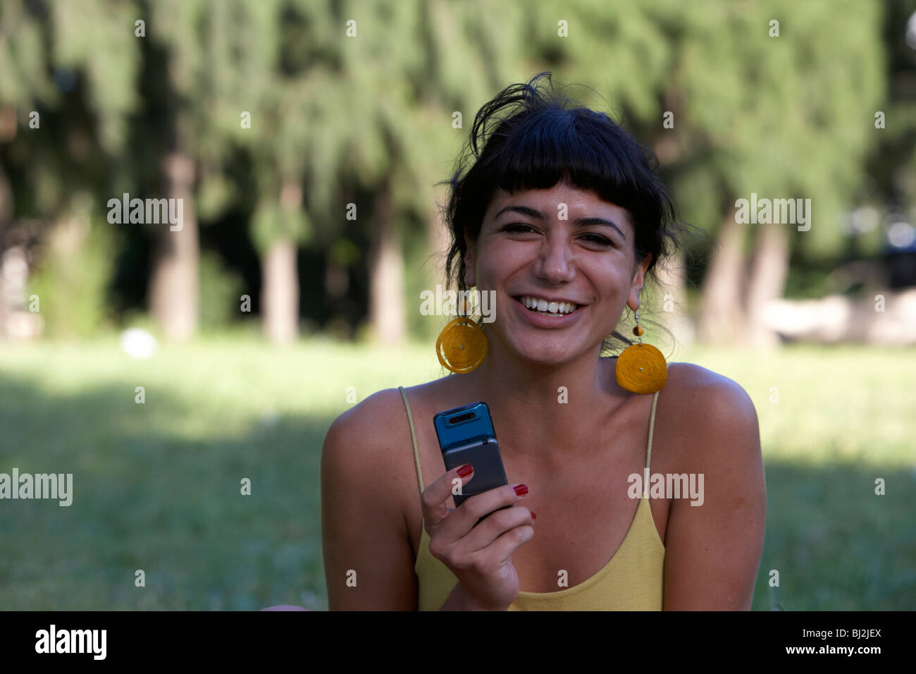 hispanische lateinische Mädchen Lachen, Lächeln, lesen eine Sms Textnachricht in der Park-Buenos Aires-Argentinien Stockfoto