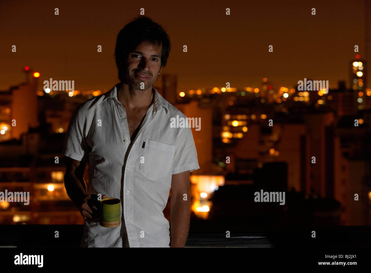 Spanisch Latein-Mann auf Dach mit einer Tasse Kaffee am Abend Stadt in den Hintergrund-Buenos Aires-Argentinien Stockfoto