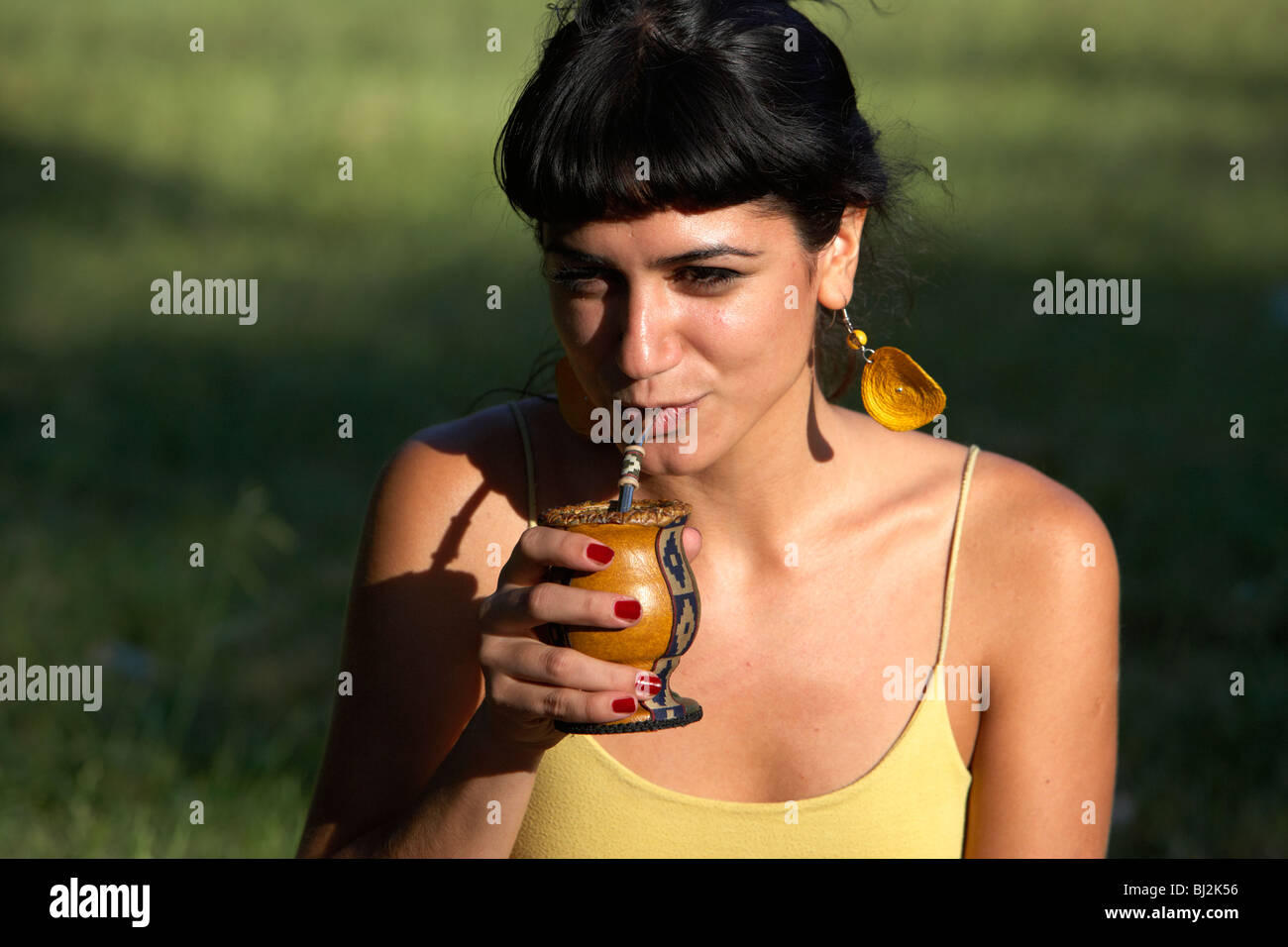junge spanische Latin Frau trinken Yerba Mate aus einem Kürbis in den Park in Buenos Aires Argentinien Stockfoto