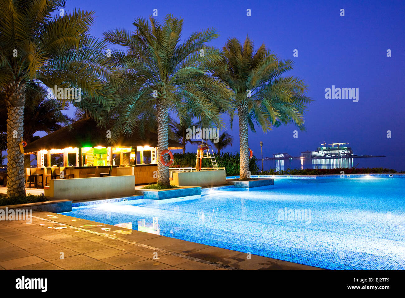 Der Pool in einem der Beachclubs auf die Palm Island Jumeirah in Dubai, Vereinigte Arabische Emirate, Vereinigte Arabische Emirate, in der Dämmerung Stockfoto