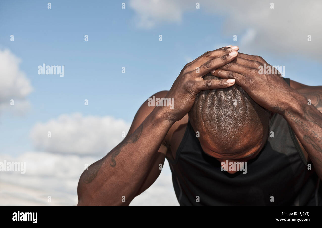 männlicher Athlet hielt Kopf in Verzweiflung Stockfoto