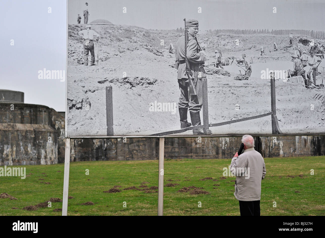 Besucher mit Audio-Guide mit Blick auf Bilder von Gefangenen im Fort Breendonk, Belgien Stockfoto