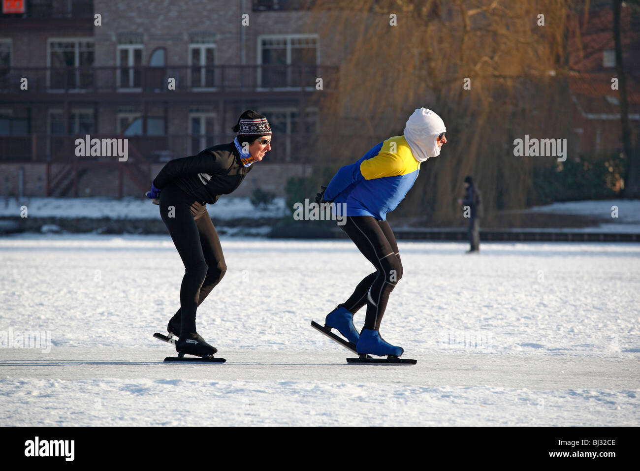 Eisläufer Schlittschuhlaufen auf dem zugefrorenen See bei Overmere Donk im Winter, Belgien Stockfoto