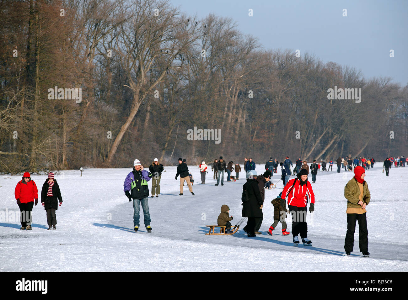 Eisläufer Schlittschuhlaufen auf dem zugefrorenen See bei Overmere Donk im Winter, Belgien Stockfoto