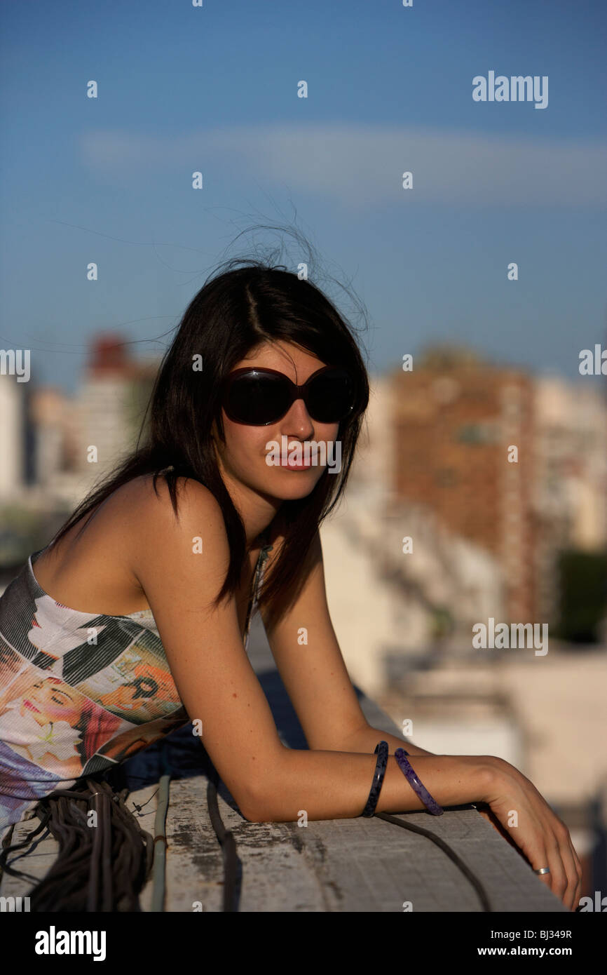 junge spanische Latin Frau entspannt stützte sich auf Dachterrasse mit Blick auf Kamera in Buenos Aires Argentinien Stockfoto
