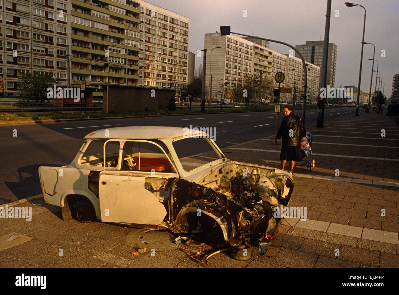 Eine deutsche Dame aus alten Deutschen Demokratischen Republik (DDR oder DDR) blickt über die Schulter nostalgisch auf verlassenen Trabant Auto. Stockfoto