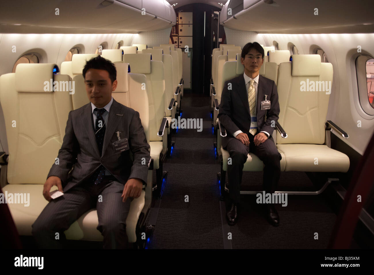 Zwei Mitarbeiter des japanischen Flugzeugherstellers Mitsubishi sitzen in einem Full-Scale Modell der ihre MRJ auf der Paris Air Show. Stockfoto