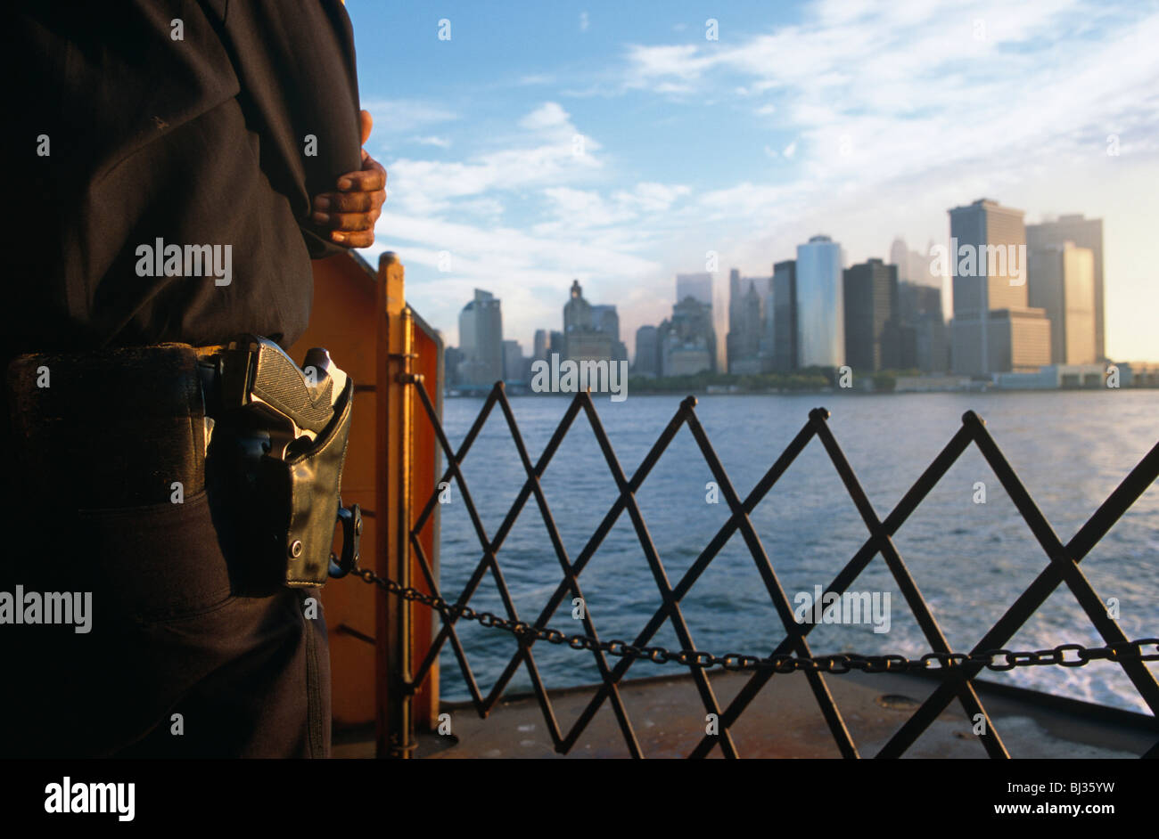 Ein bewaffneter Polizist in New York City Police Department (NYPD) steht Wache an der Front (der Bogen) von der Staten Island Ferry. Stockfoto