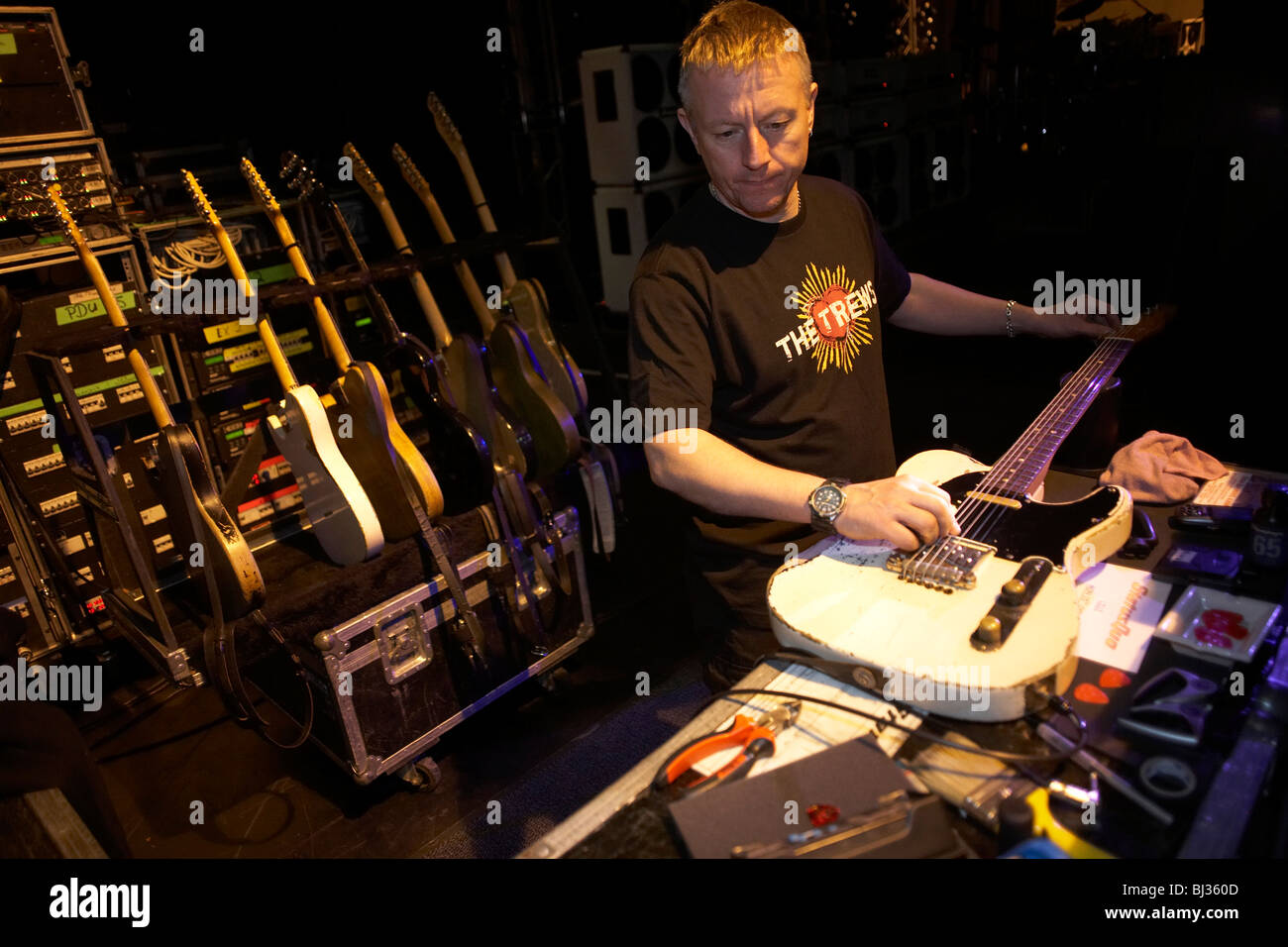 Gitarrentechniker Lloyd Gilbert der Rockband Status Quo Melodien eines der Band Gitarren durch Dehnung die Saiten. Stockfoto