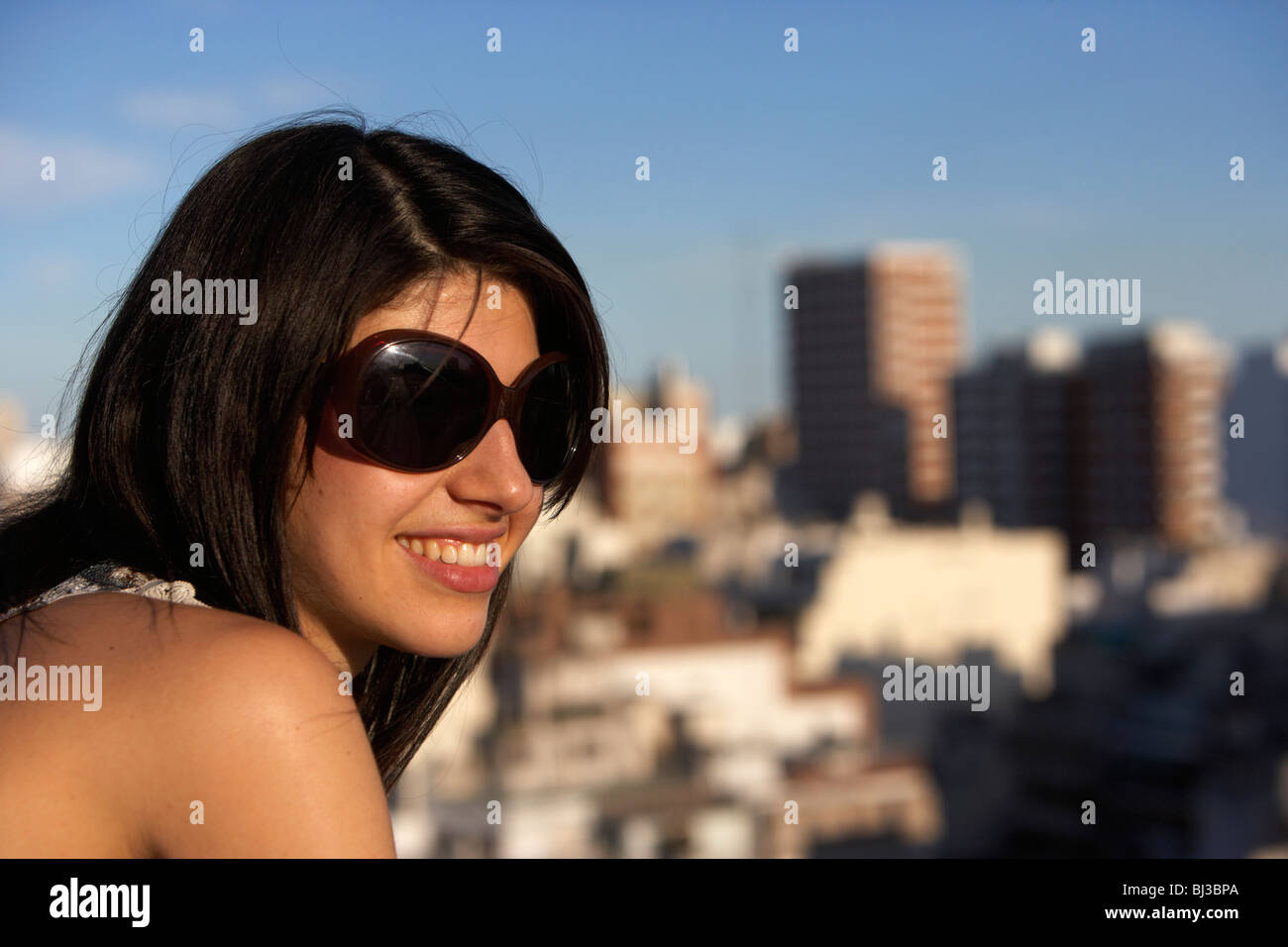 junge hispanic Latin Frau mit dunkelbraunen Haaren mit Sonnenbrille auf der Suche an einem heißen Sommertag Stockfoto