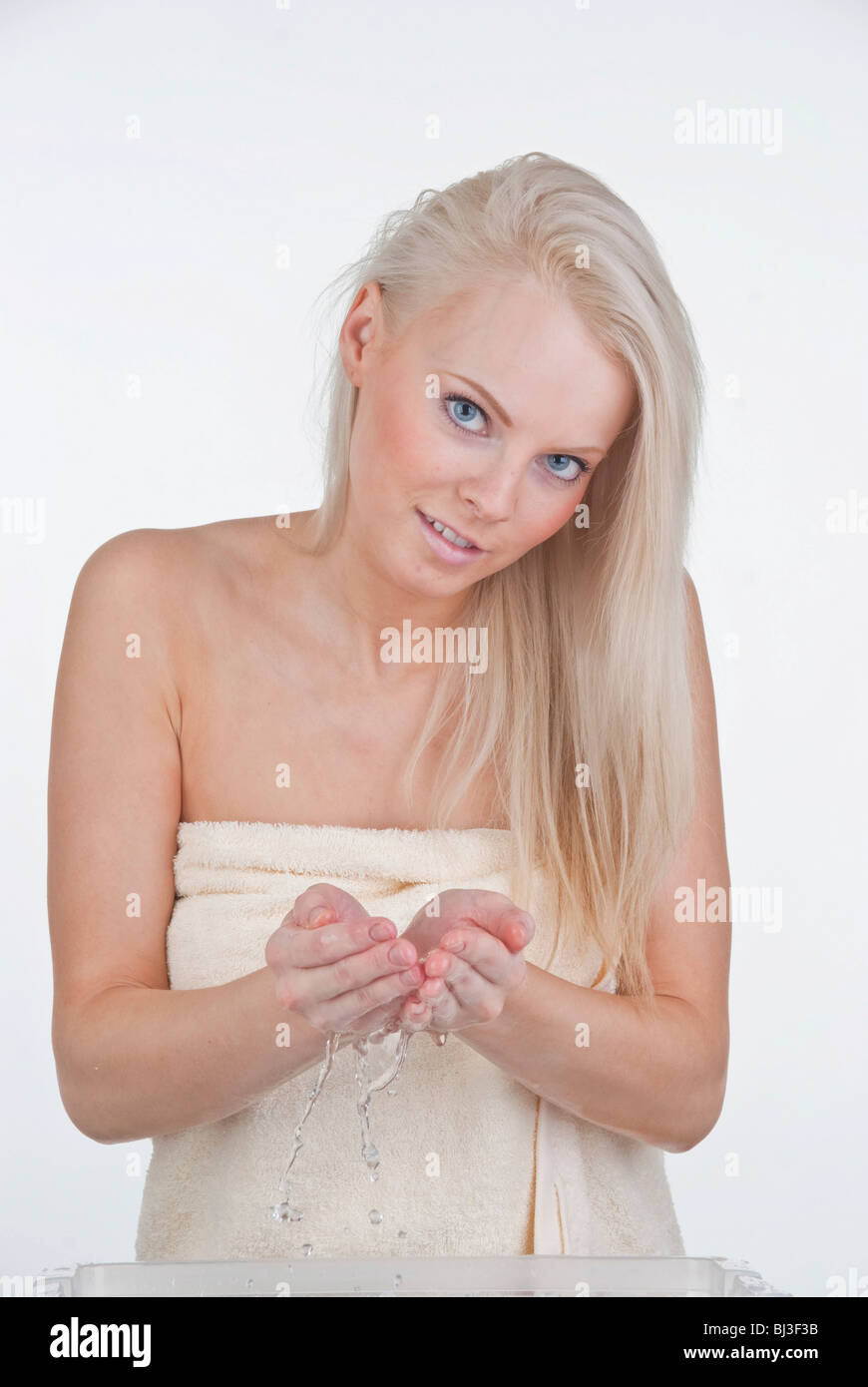 Frau, die ihr Gesicht mit Wasser waschen Stockfoto