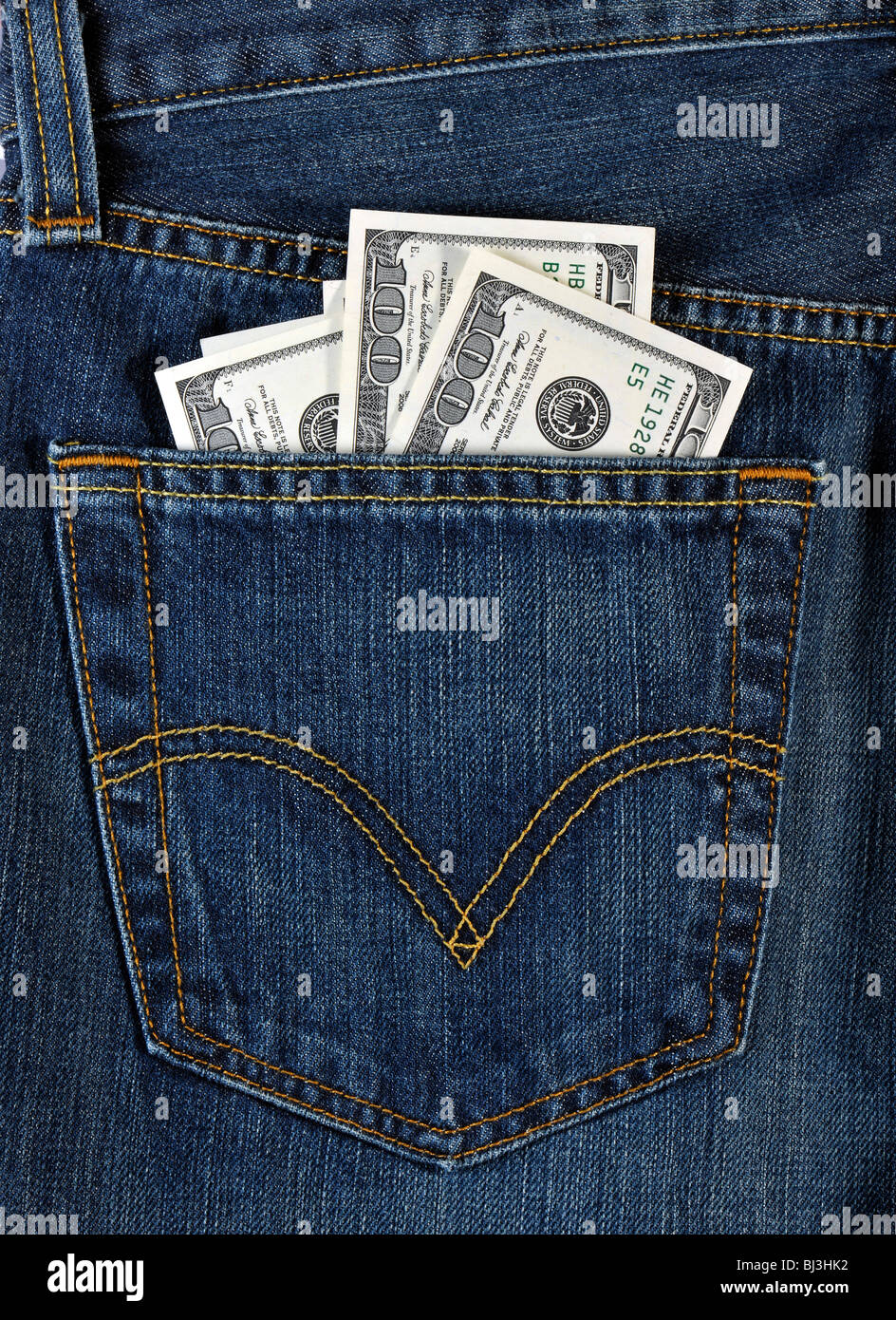 Mehrere 100-Dollar-Scheine in eine blaue Jeans Gesäßtasche Stockfoto