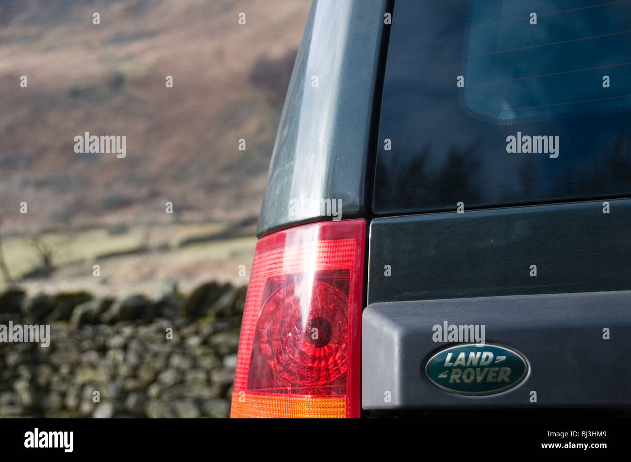 Land Rover Name auf Rückseite des Discovery 3 mit aus Fokus Moor hinter Stockfoto