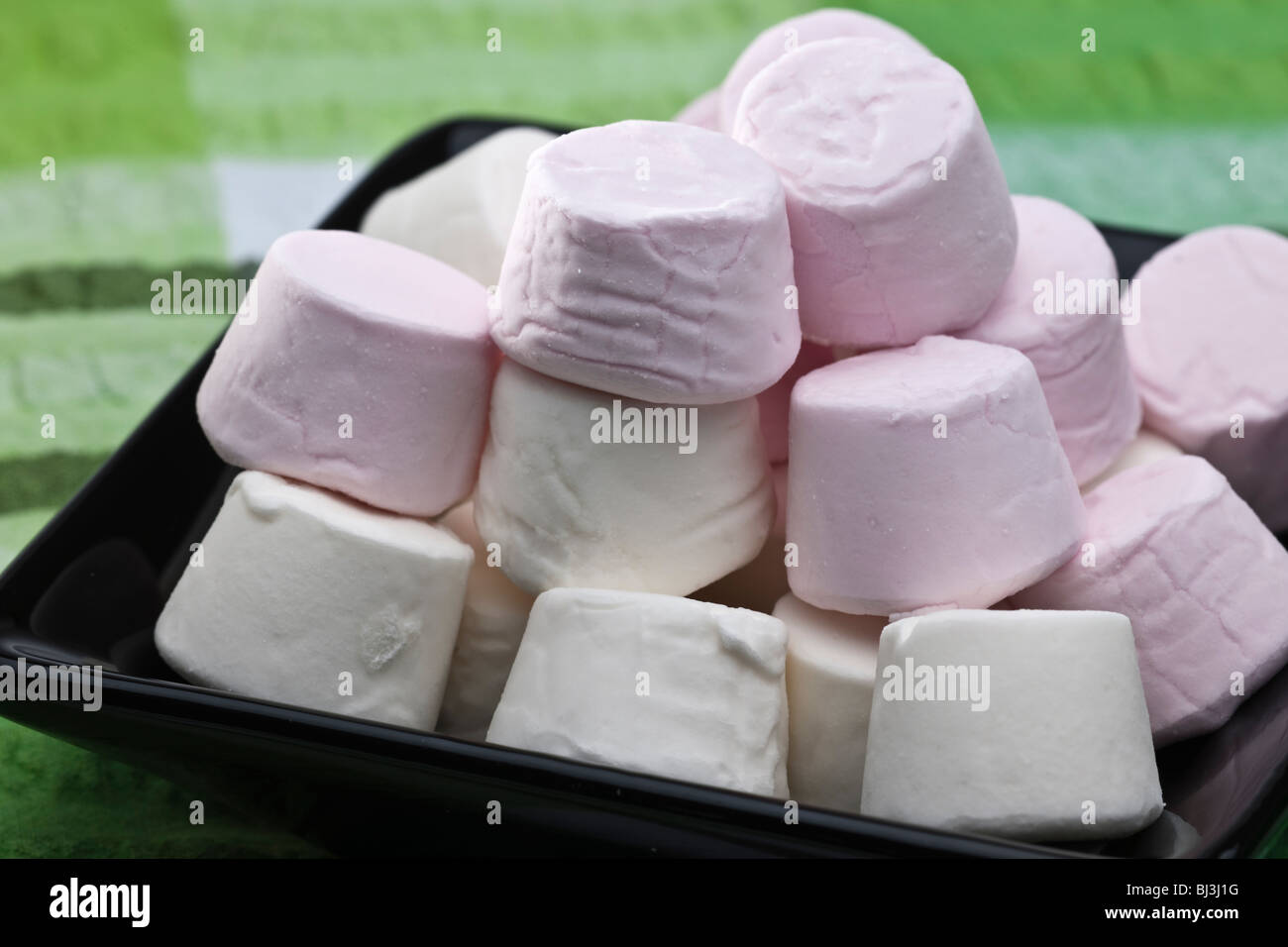 Haufen von rosa und weiße Marshmallows auf einer schwarzen Platte Stockfoto