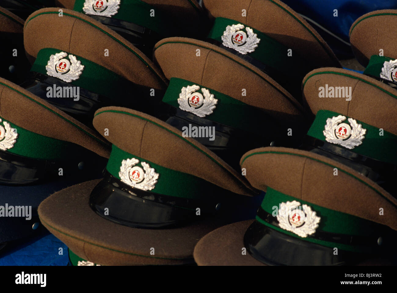 Auf einer Tabelle am Brandenburger Tor in Berlin, ein Jahr nach dem Fall der Berliner Mauer, Spitzen Kappen der DDR angezeigt. Stockfoto