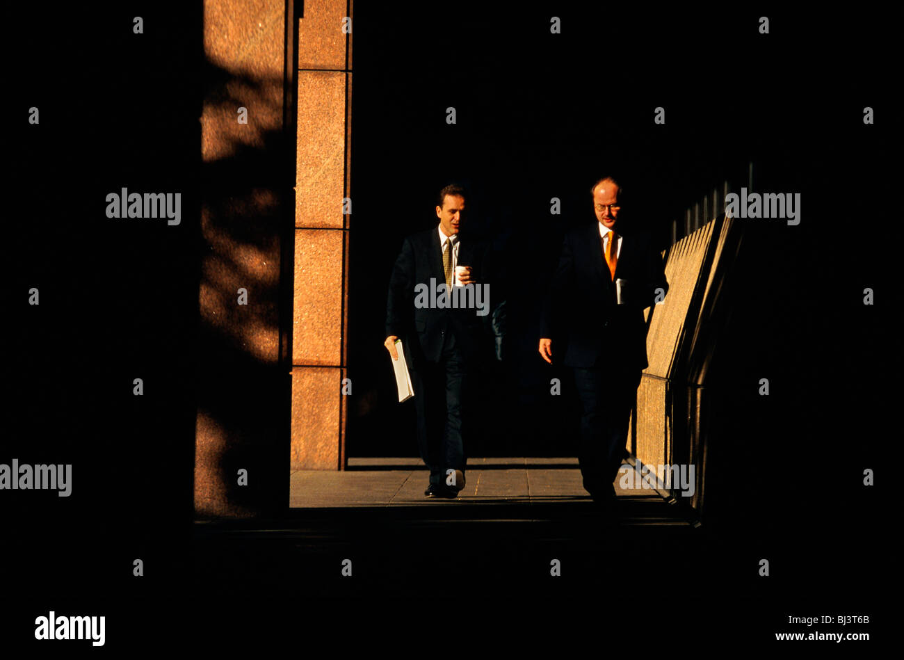 Zwei Geschäftsleute eine jünger als die anderen, die sein Vorgesetzter sein Tempo durch das Anwesen Broadgate während einer Pause am Vormittag Stockfoto