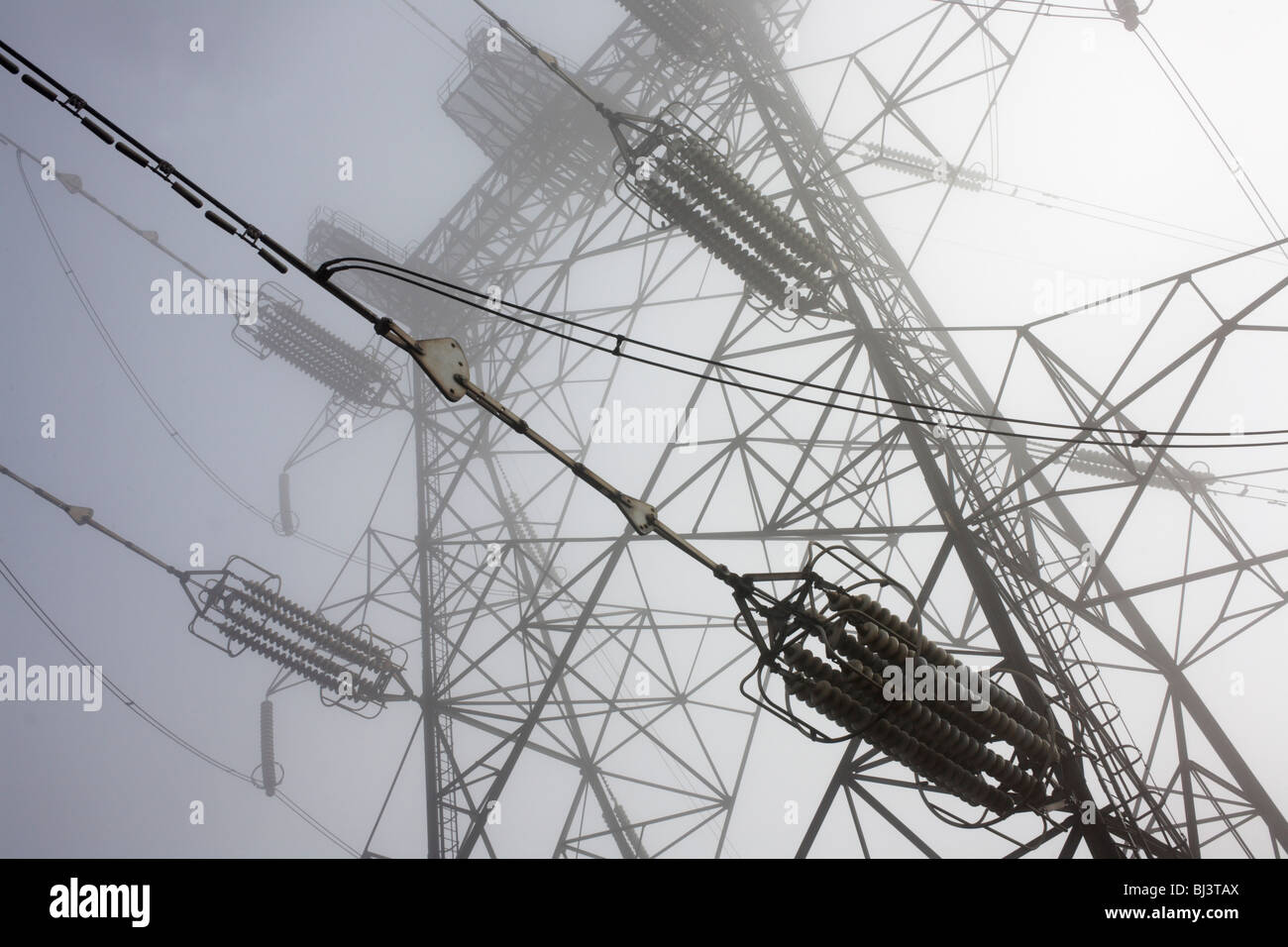 Pylon Elektrokabel erstrecken sich in frühen Morgennebel über Swanscombe, Kent. Stockfoto