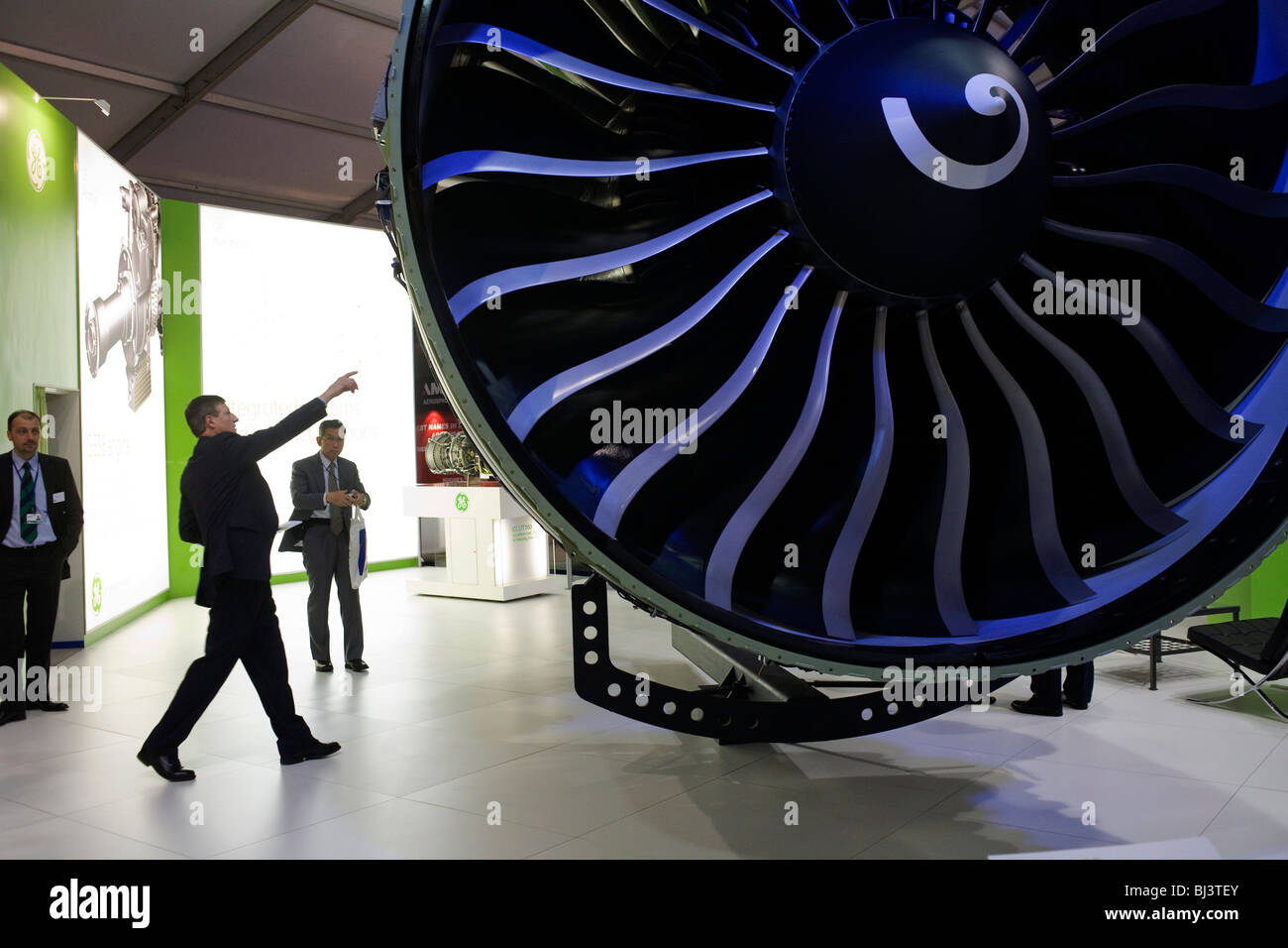 Ein Besucher, der General Electric Messestand verweist auf eine Funktion auf eine massive, GE90-115 b Turbofan-Triebwerk. Stockfoto