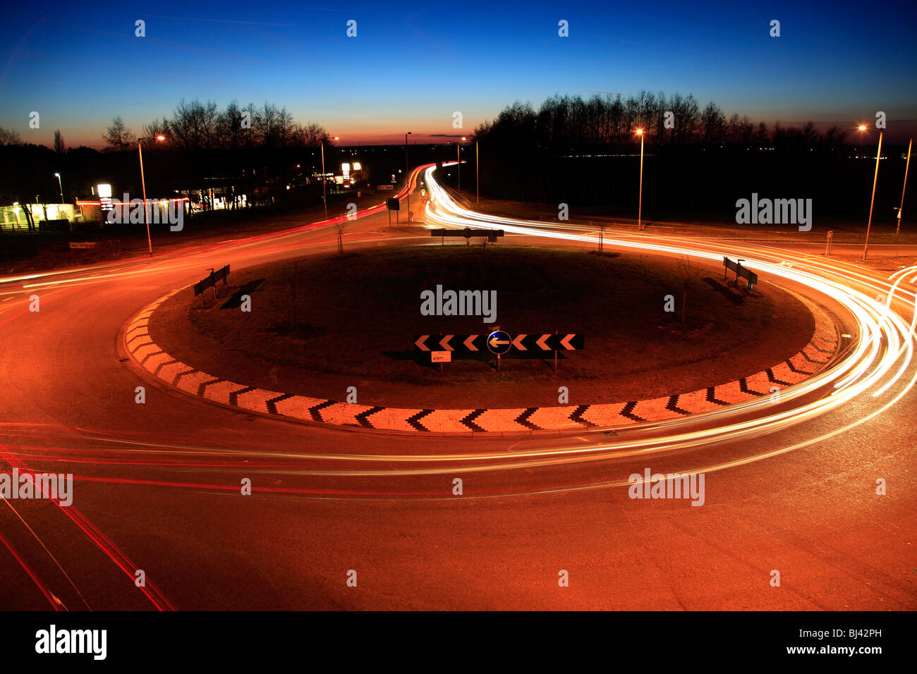 Autos und Ampel Trails auf einen Kreisverkehr Stockfoto