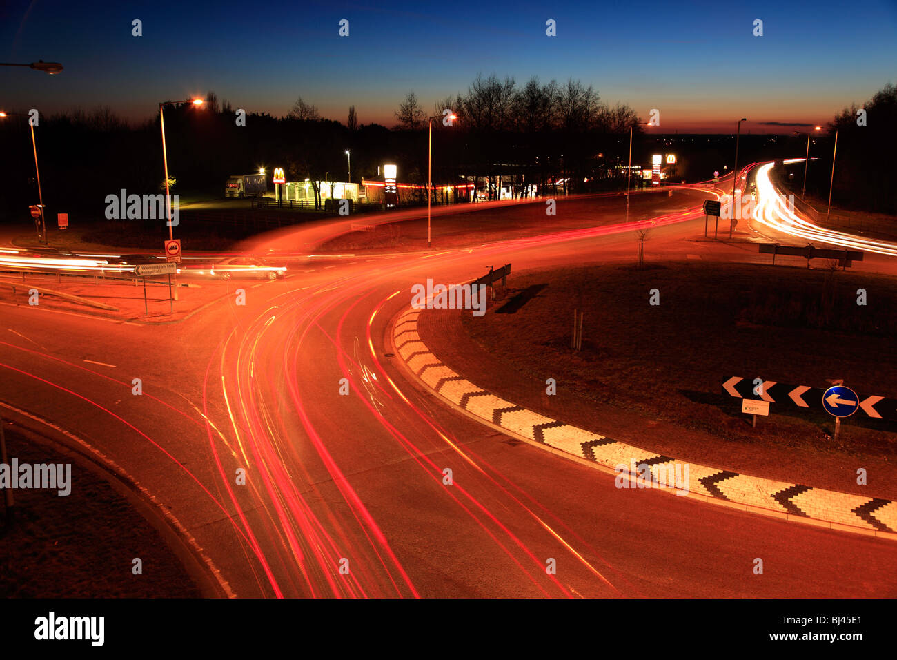 Autos und Ampel Trails auf einen Kreisverkehr Stockfoto