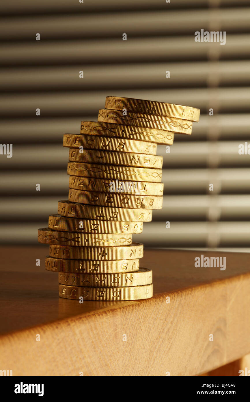 Stapel von Pfund-Münzen am Rand der Tabelle Stockfoto