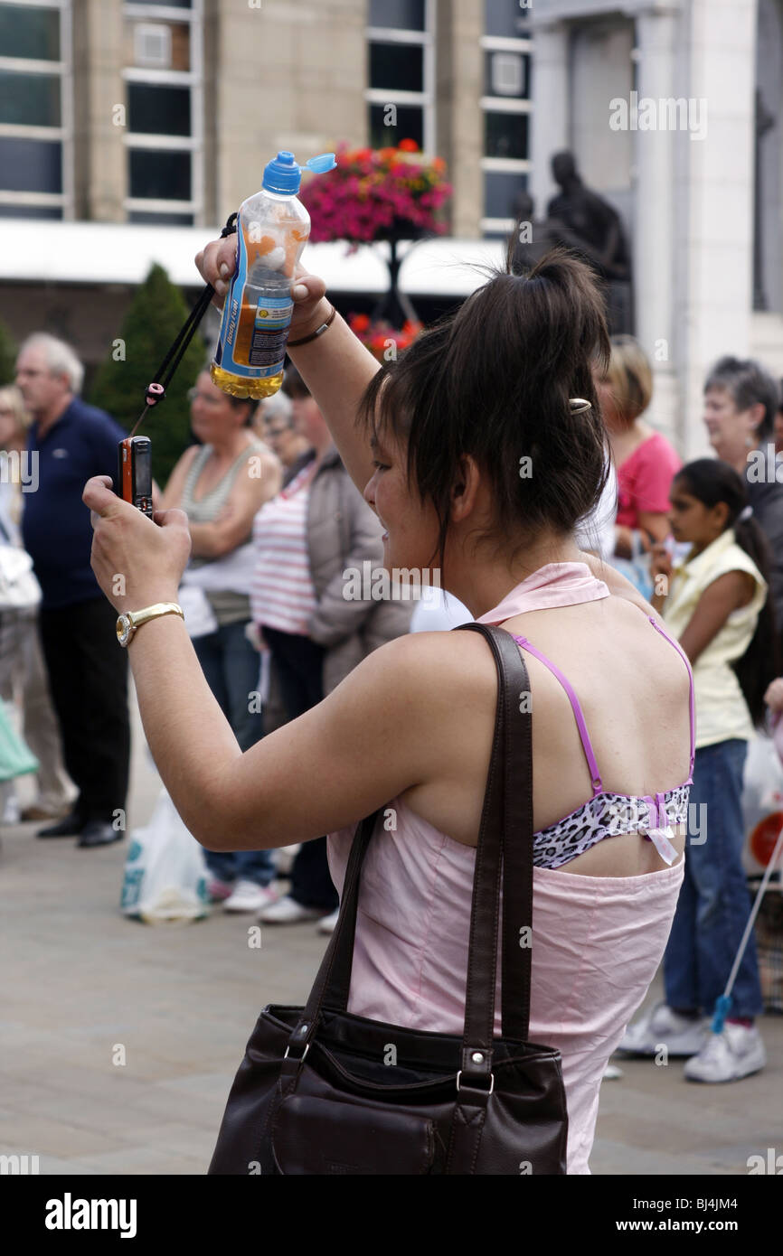 Junge Frau, die eine Aufnahme mit ihrer Handy-Kamera im Vereinigten Königreich Stockfoto