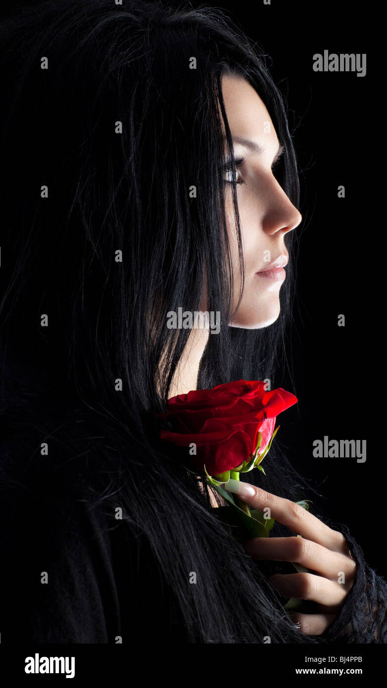 Brünette Goth-Frau mit rose Porträt. Dunkle Farben. Stockfoto