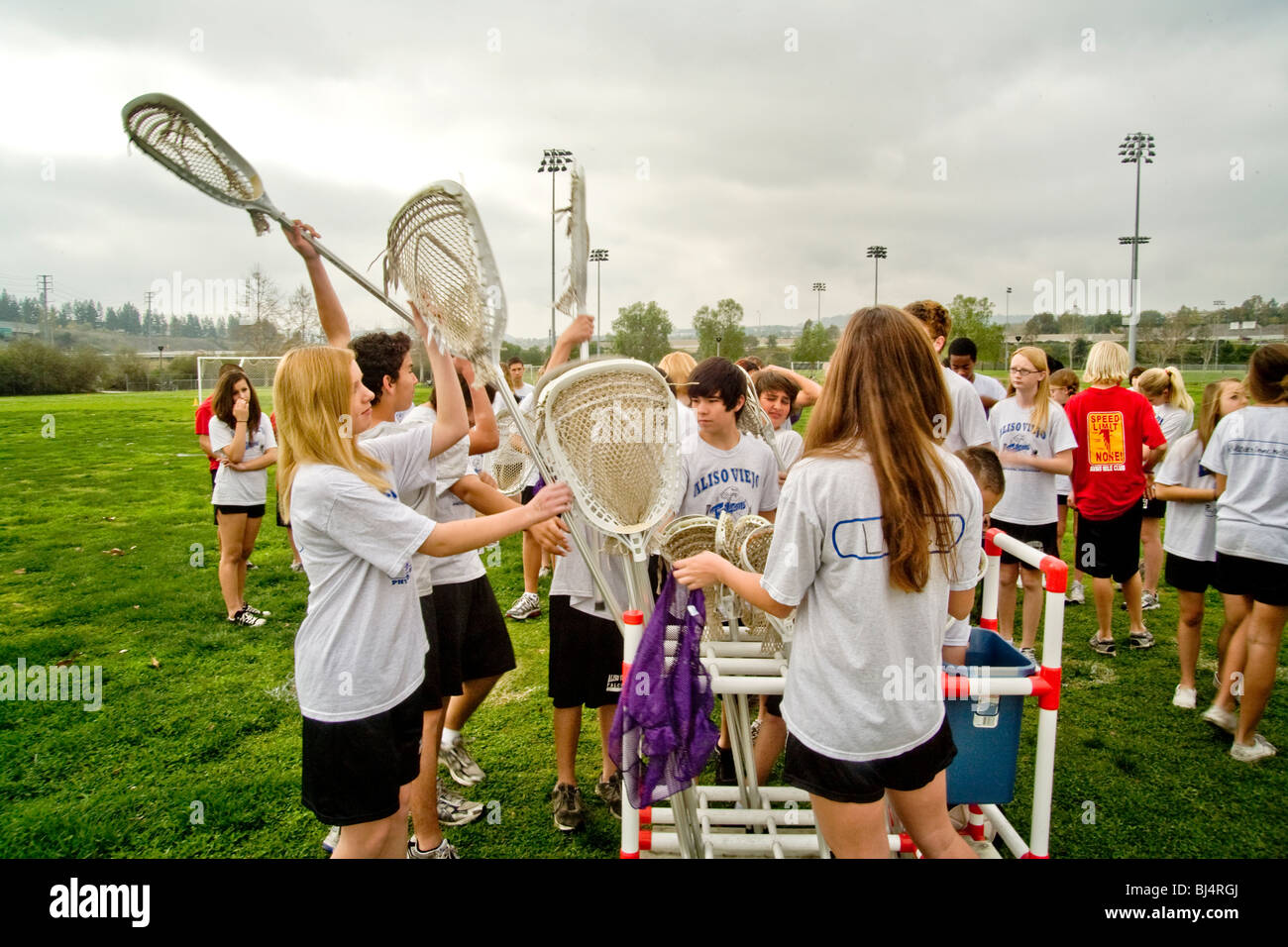 Uniformierte Mittelschüler / innen wählen Sie Lacrosse Sticks während Sportunterricht im Freien in Aliso Viejo, Kalifornien. Stockfoto