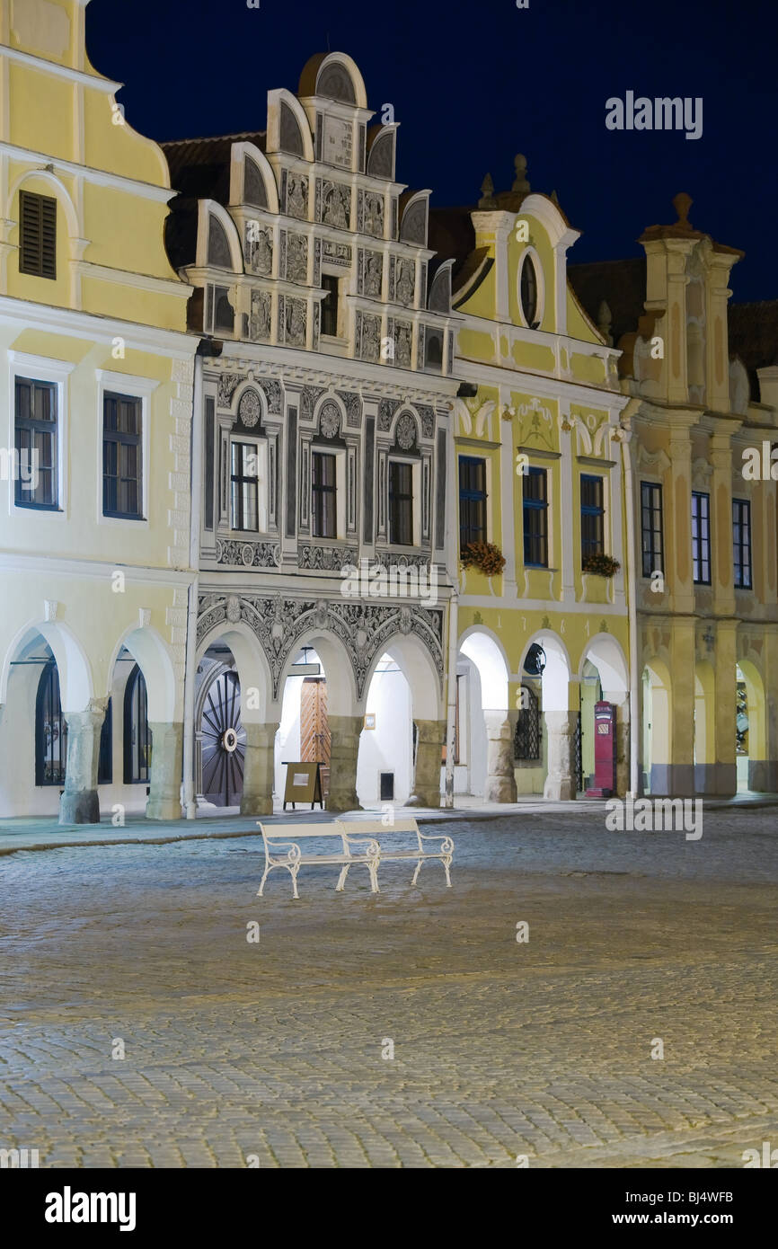 Beleuchtete Stadt Häuser mit Arcade auf dem Platz in Telc, Böhmen - Tschechien, mit leeren Bank während der Dämmerung. Stockfoto