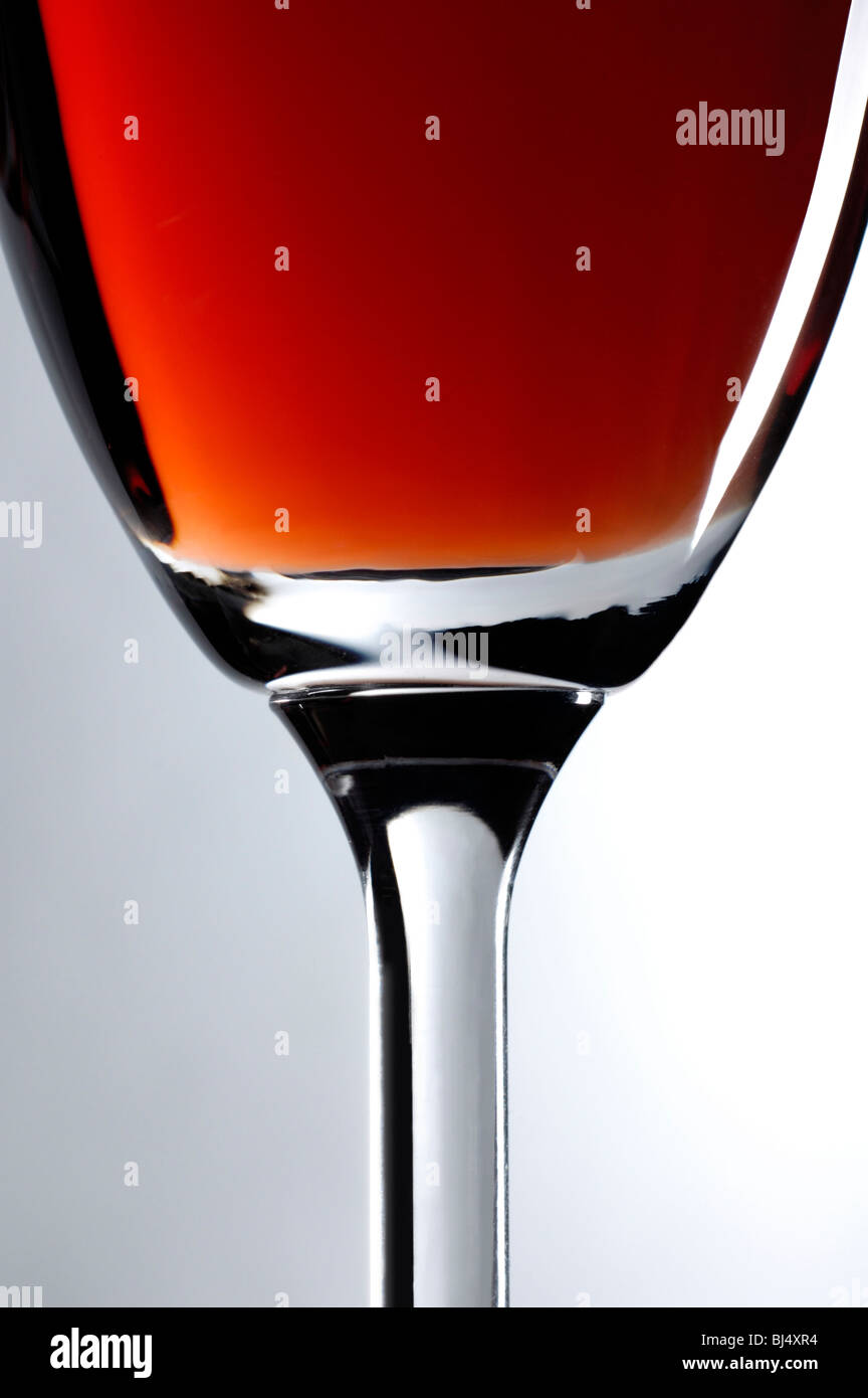 Weinglas mit roten Wein Nahaufnahme künstlerischen Stillleben über grauen Hintergrund vertikale Ausrichtung Stockfoto