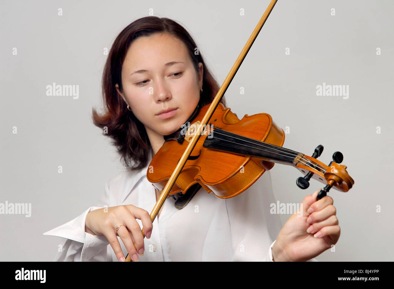 Mädchen tuning Violine isoliert Silhouette auf grauem Hintergrund Stockfoto