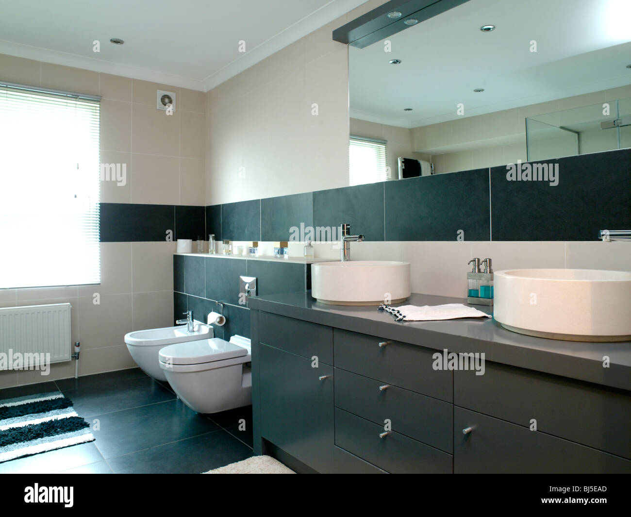 Moderne Badezimmer in weißen und braunen Fliesen gefliest sein und Ihr Waschbecken, Lagerung, Spiegel, Glas-Duschkabine, Stockfoto