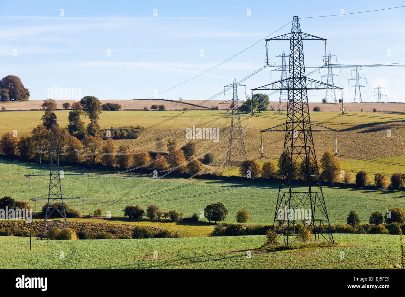 Blot on the Landscape - Pylons, die durch die Landschaft von Cotswold in der Nähe von Cassey Compton, Gloucestershire, England, Großbritannien, Streifen Stockfoto