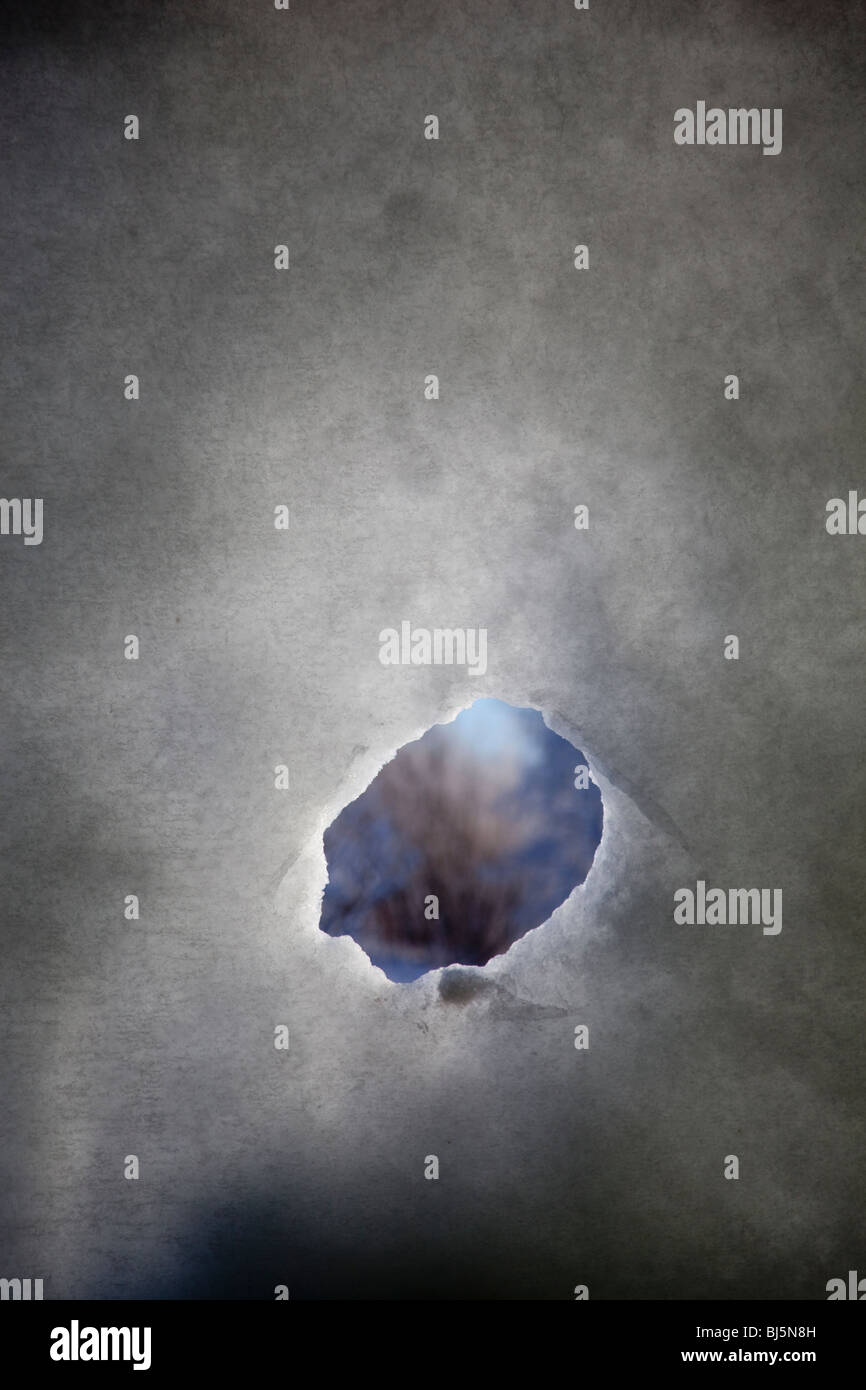 Kleines Peep-Loch an dünner transparenter Schneewand Stockfoto