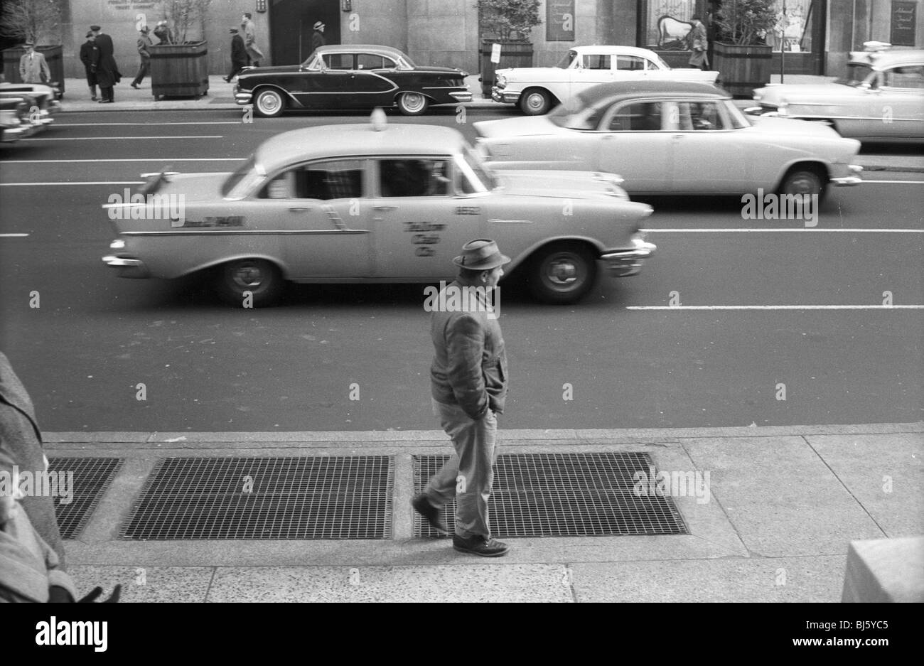 Ein 1950er Jahre Taxi geht ein Mann und anderen 50er Jahre Autos in Philadelphia. schwarze und weiße horizontale amerikanische Transport Stockfoto