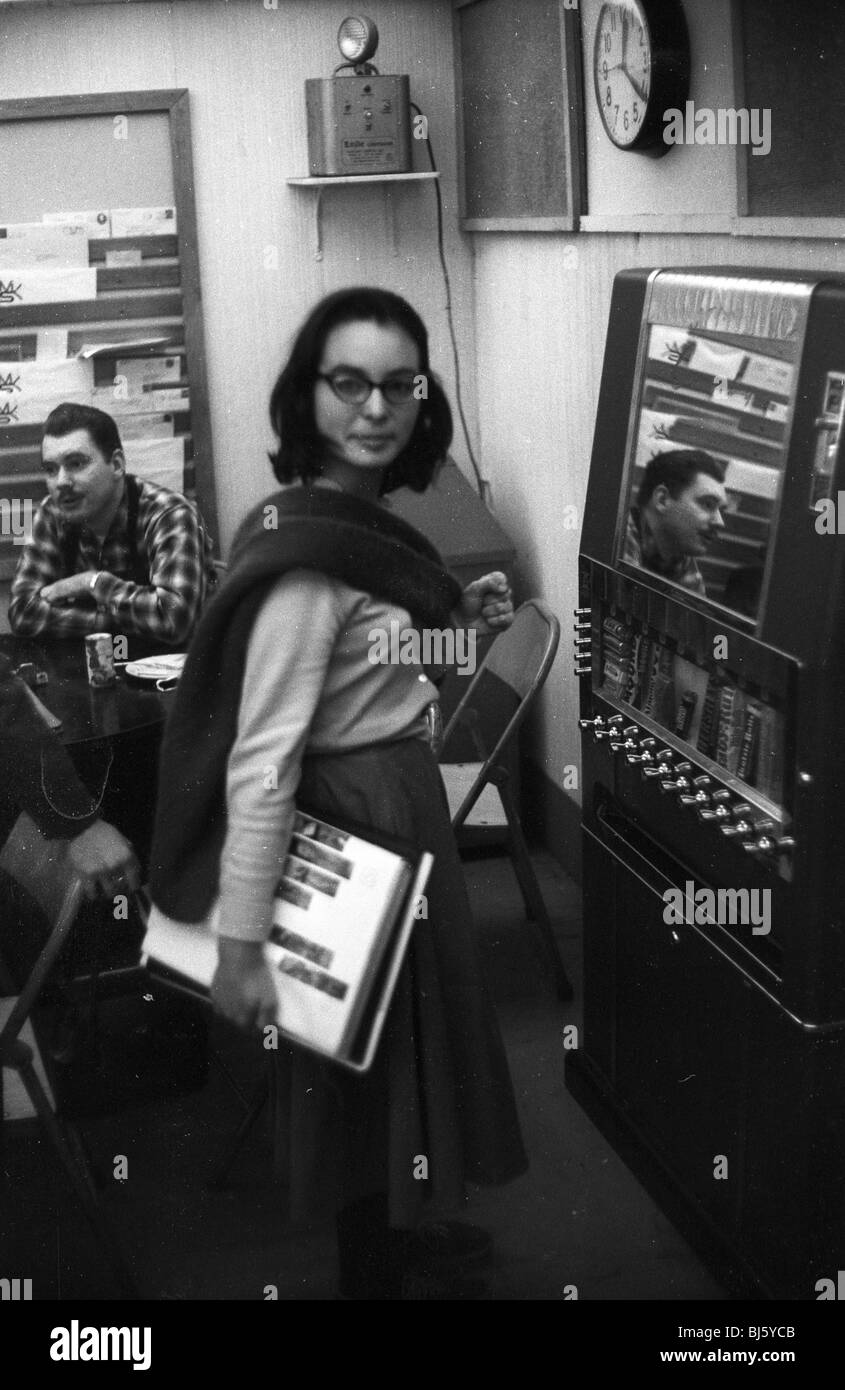 Modische Hipster Frau stand am Automaten Cafeteria Kunstschule der 1950er Jahre. vertikale schwarze und weiße Brünette coolen beatnik Stockfoto