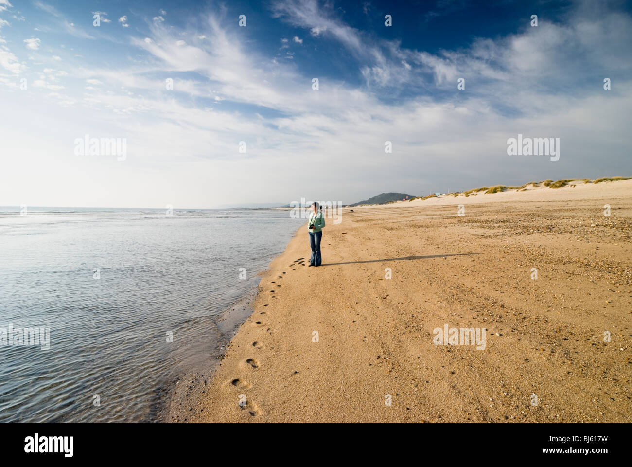 Eine Frau stand am Atlantischen Ozean sandigen Strand in Esposende Dorf, Provinz Minho, Portugal Stockfoto