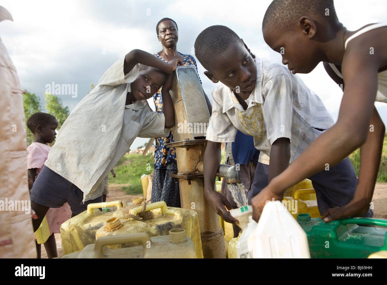 Kinder holen frisches Trinkwasser in einem Bohrloch in Amuria Bezirk, Teso Region, Uganda. Stockfoto