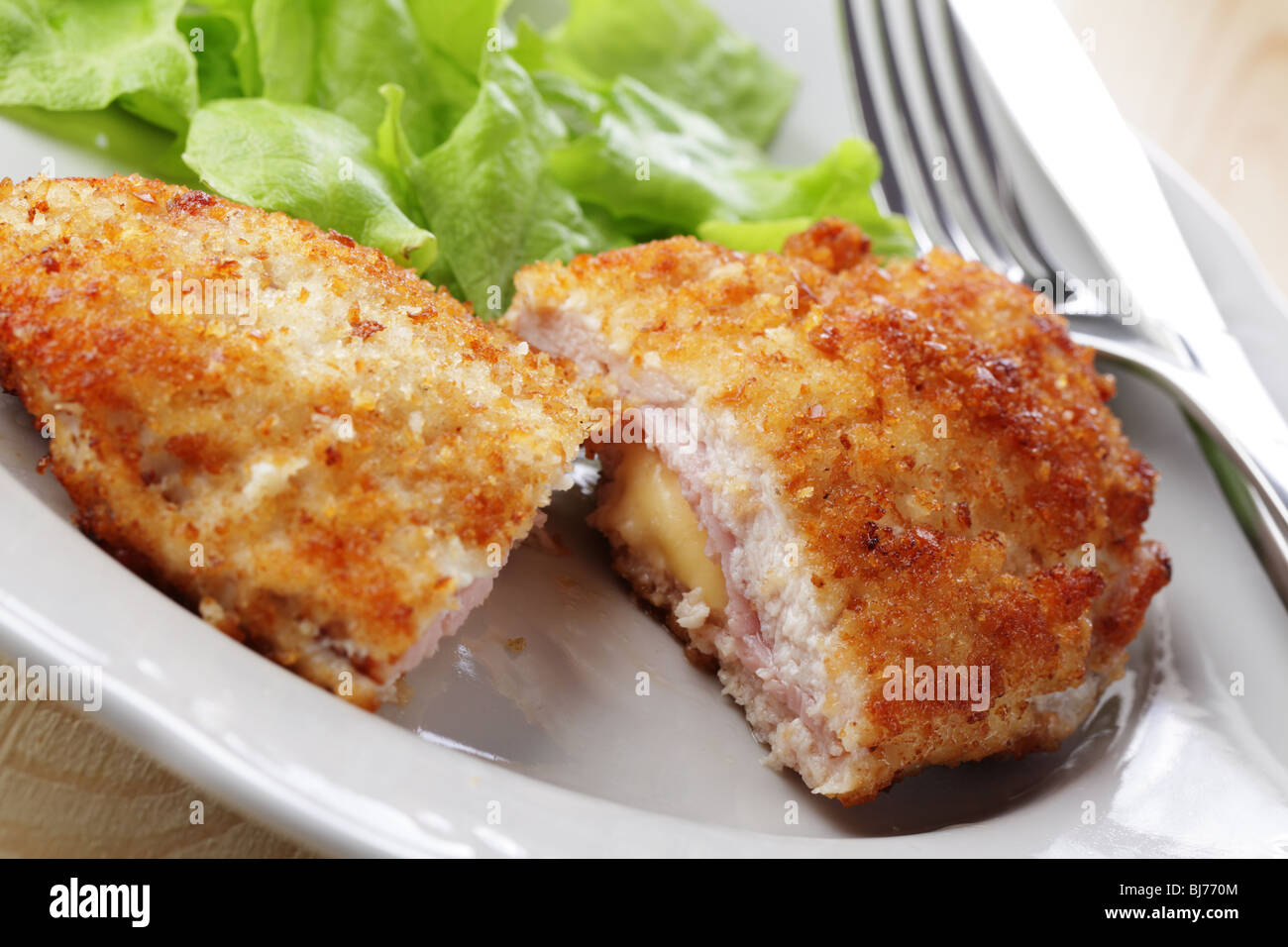Hähnchenschnitzel Cordon Bleu mit Salat auf weißen Teller Stockfoto