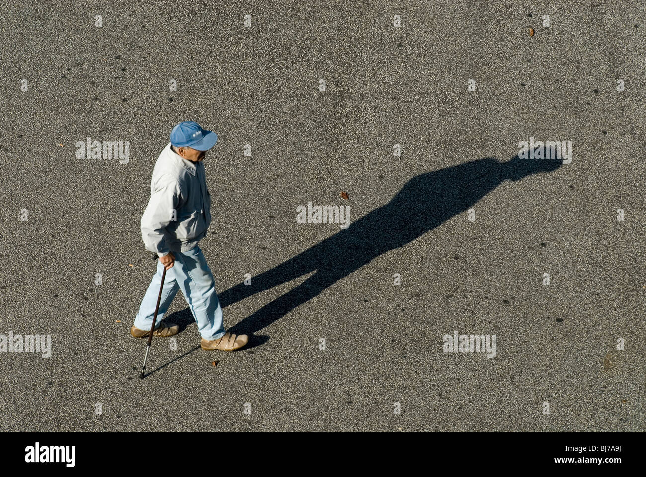 Ein Alter Mann mit einem Stock zu Fuß auf dem Bürgersteig in Basel, Schweiz Stockfoto