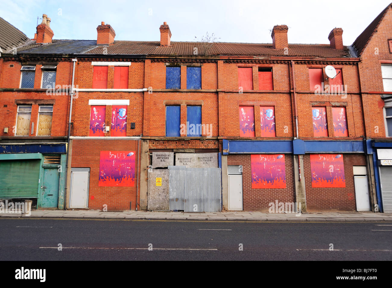 Geschäfte geschlossen und mit Brettern vernagelt in Edge Hill / Kensington Bereich von Liverpool. Stockfoto