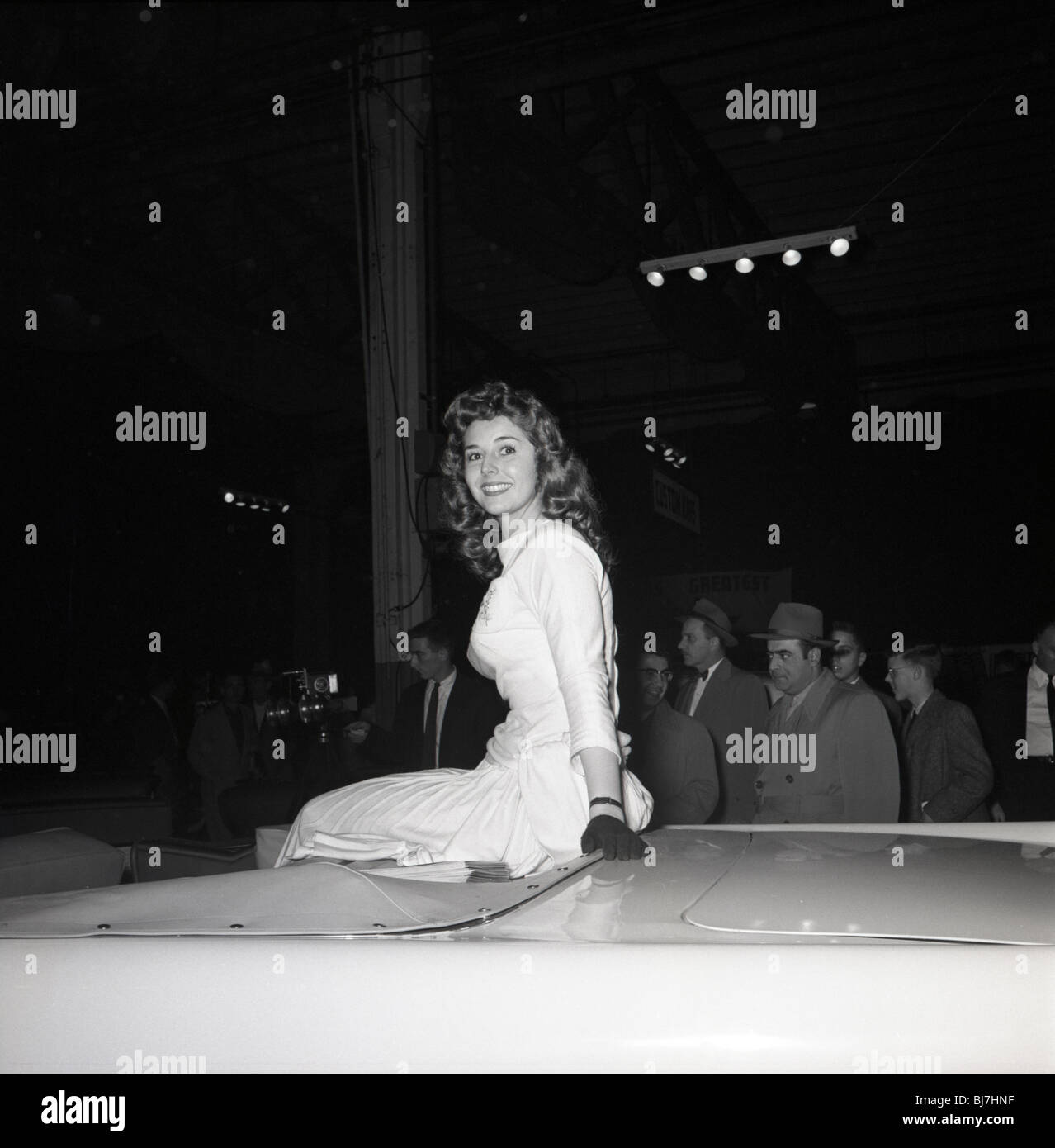 Hübsche Frau im Kleid sitzt auf Top-Auto bei Auto-Show in Philadelphia und Umgebung in den späten 1960er Jahren. Stockfoto