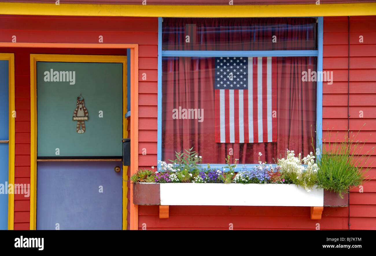 Ein Multi farbige Ferienhaus Apartment mit einer amerikanischen Flagge im Fenster. Stockfoto