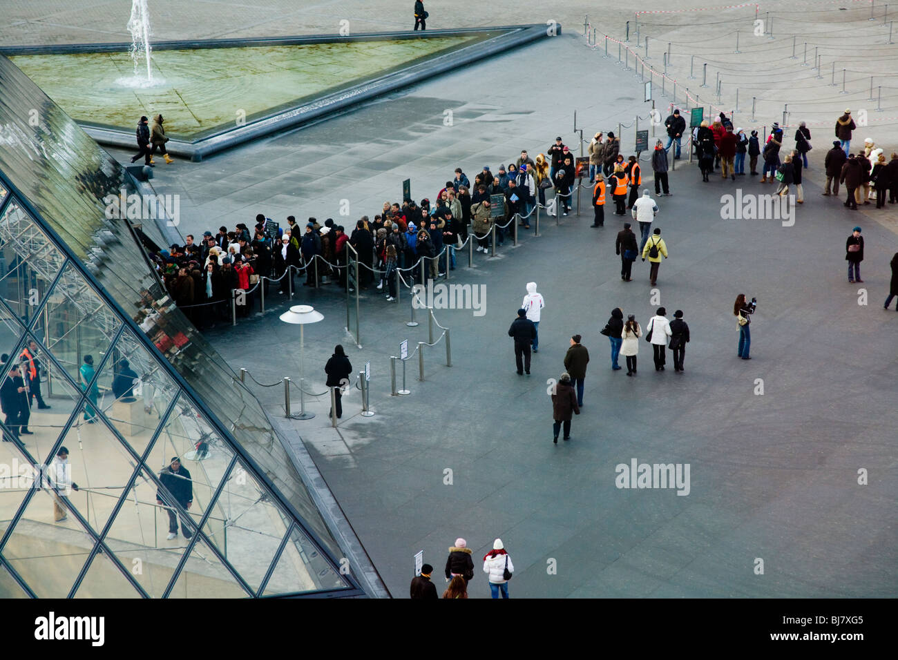 Menschen in die Warteschlange zum kostenlosen Eintritt in das Louvre Museum / Musée / Palais du Louvre, neben der Glaspyramide. Paris, Frankreich. Stockfoto