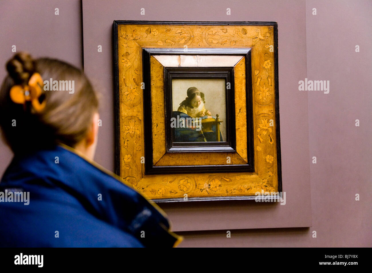 Frau Touristen betrachten die Spitzenklöpplerin Gemälde von Vermeer, Jan. Das Louvre, Paris. Frankreich. Stockfoto