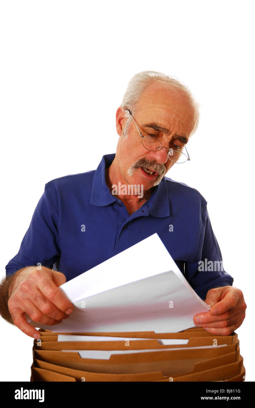 Ältere Mann aussortieren Rechnungen und Papier ans Werk Stockfoto