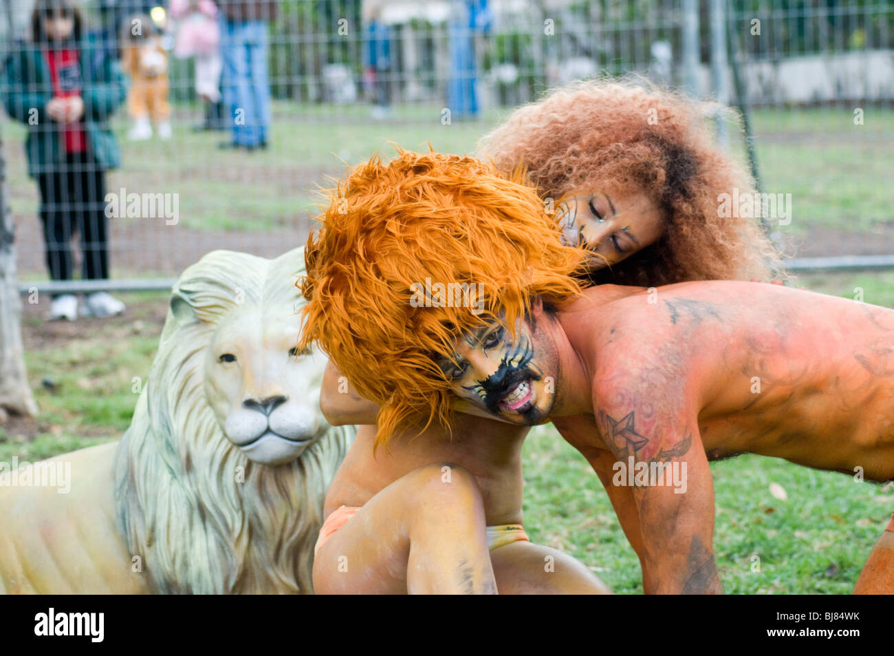 Mann und Frau in Löwe und Löwin Kostüme und Bodypaint in einem Käfig Stockfoto