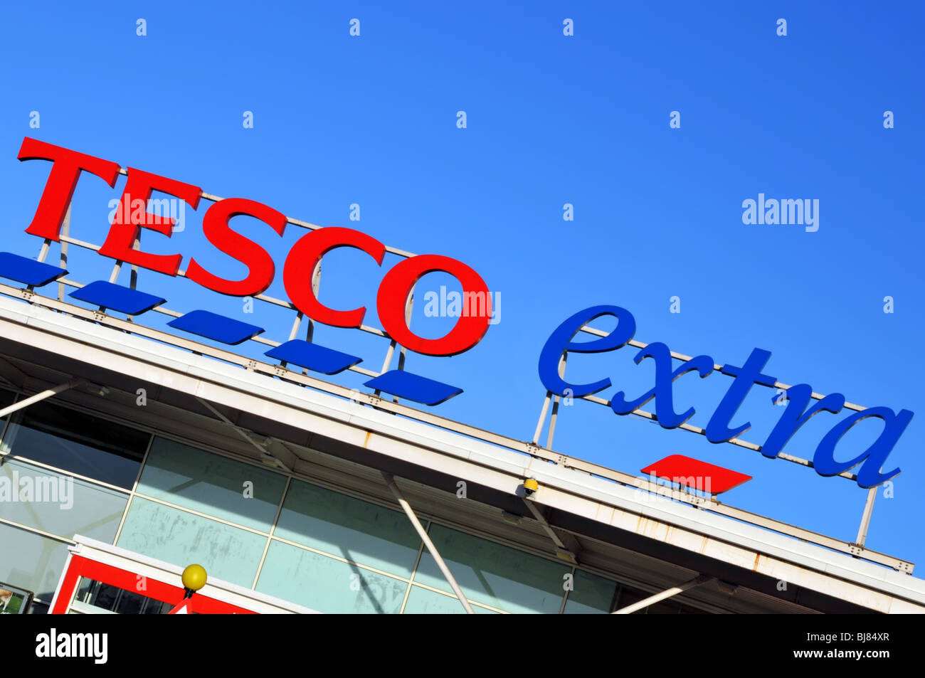 Nahaufnahme abgewinkelte Ansicht Tesco Extra Supermarkt Logo Marke & Geschäft Schild über Einzelhandel Geschäft Einkaufsräume blauer Himmel Tag in Romford London England Großbritannien Stockfoto