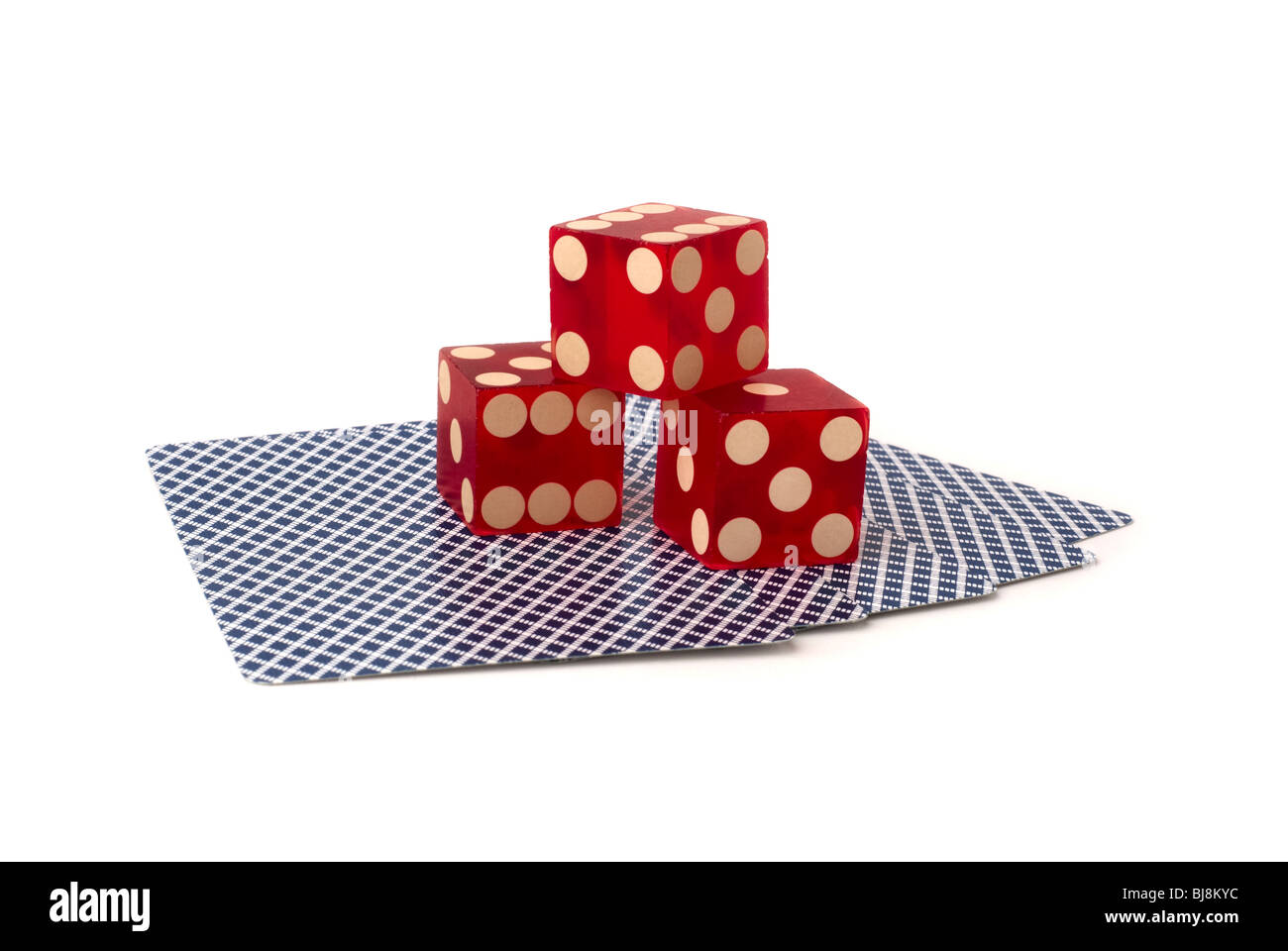 drei rote Würfel auf fünf kopfüber Spielkarten mit blauem Muster, gedreht im Studio auf weißem Hintergrund Stockfoto
